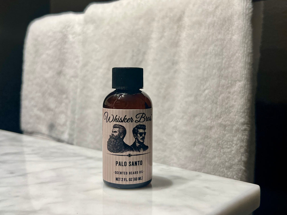 Bottle of Whisker Bros Palo Santo scented beard oil on a marble surface with a white towel in the background.