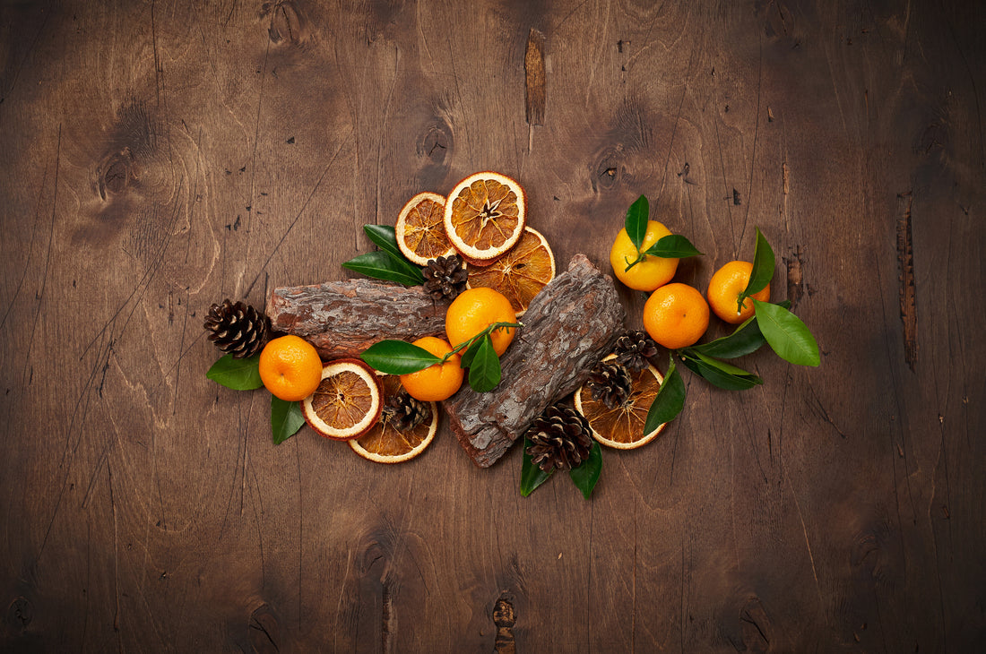 Decorative arrangement of oranges and pine cones on a wooden background