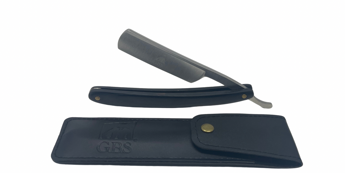 Straight razor with black leather case on a white background