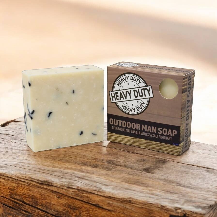 Bar of soap and its packaging on a wooden surface with a warm background